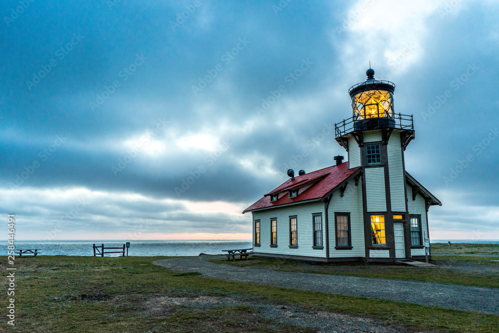 Sunset at Historical Lighthouse In Mendocino California with Clouds and the Pacific Ocean on the Background