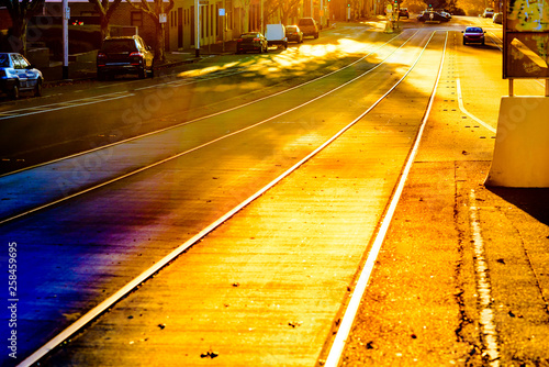 Melbourne city tram tracks are glowing with golden afternoon sunlight captured through a vintage camera lens