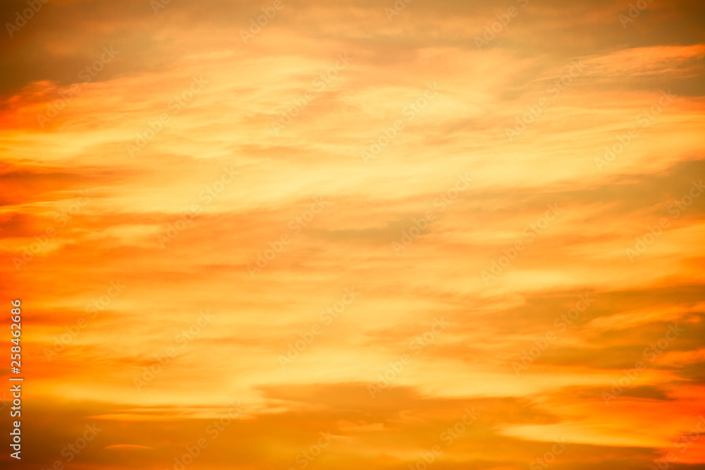 Clouds in an evening sky that are brilliantly lit from below with yellow and peach colors.