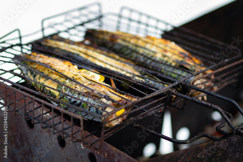 Mackerel fish with lemon and spices on the rack closeup