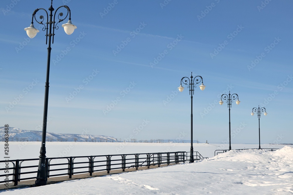Winter landscape of Volga embankment with lampposts