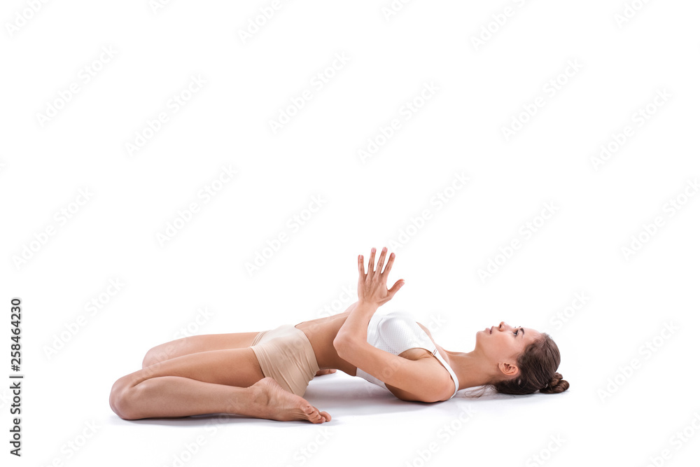 Fototapeta premium Health, sport and yoga concept - sporty woman doing relax exercise on the floor isolated.