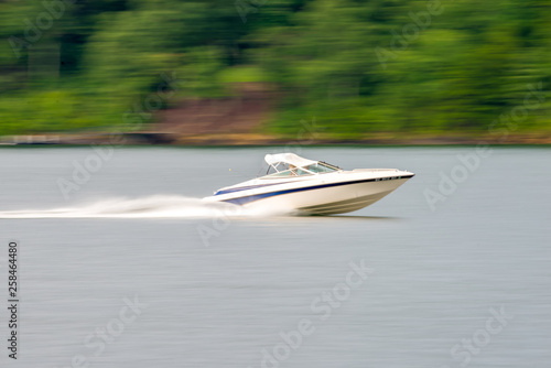 abstract blur of nature and fast moving boat on lake