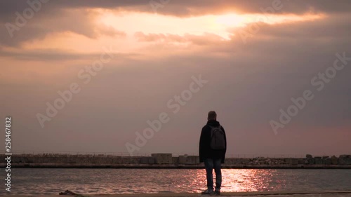 Thessaloniki / Greece 28 march 2019 :A man is standing and staring the sea he is alone and enjoy the good weather and the sunset