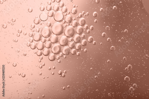 Blurred abstract background. Abstract pink circles and drops of different sizes, the texture of the liquid. Cropped shot, horizontal, blurred, free space, nobody, toned pink.