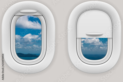 Fenster im Flugzeug mit Blick auf eine Insel unter Wolken