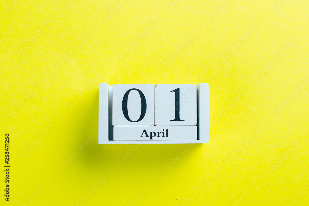 April Fools' Day Concept. Wooden calendar blocks - date of 1 April. Yellow Background. Flat lay April Fools' Day Concept. Wooden calendar blocks - date of 1 April. Yellow Background. Flat lay