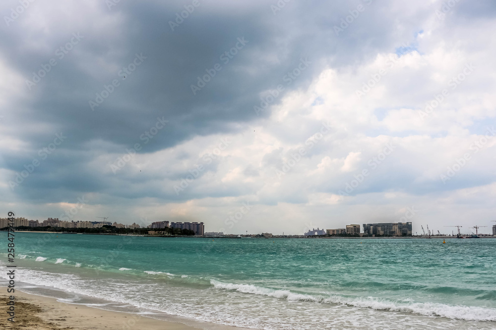 Horizon of Seascape, water waves at Jumeirah Beach under cloudy sky in Dubai, United Arab Emirates