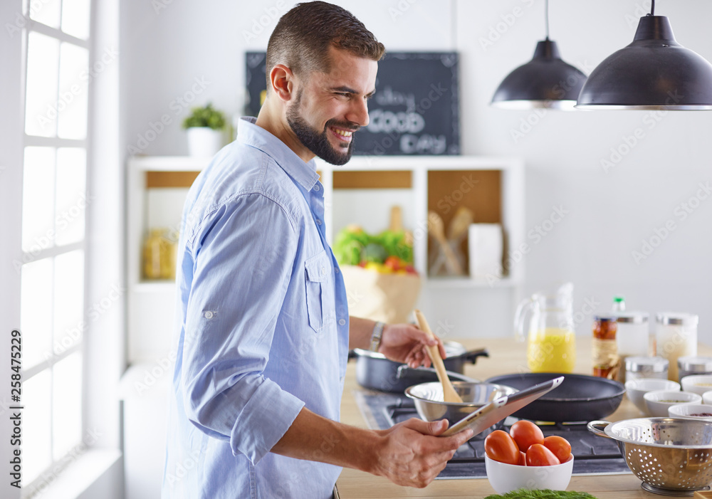 Smiling and confident chef standing in large kitchen Smiling and confident chef standing in large kitchen