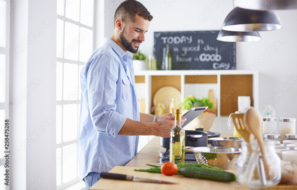 Smiling and confident chef standing in large kitchen Smiling and confident chef standing in large kitchen