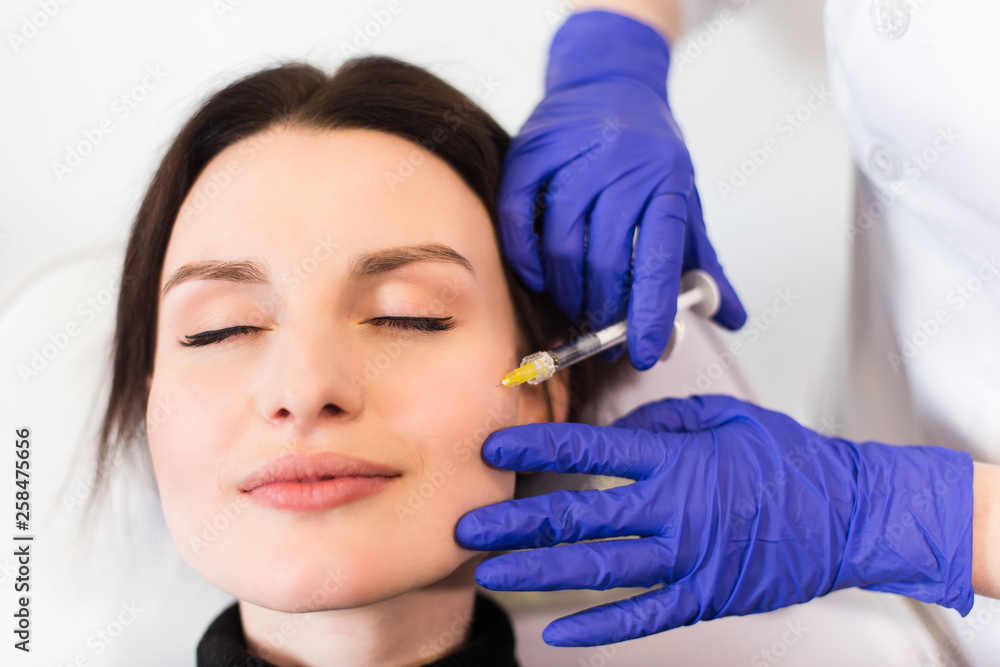 A woman on the procedure of injections in a cosmetology clinic. lose top view A woman on the procedure of injections in a cosmetology clinic. lose top view