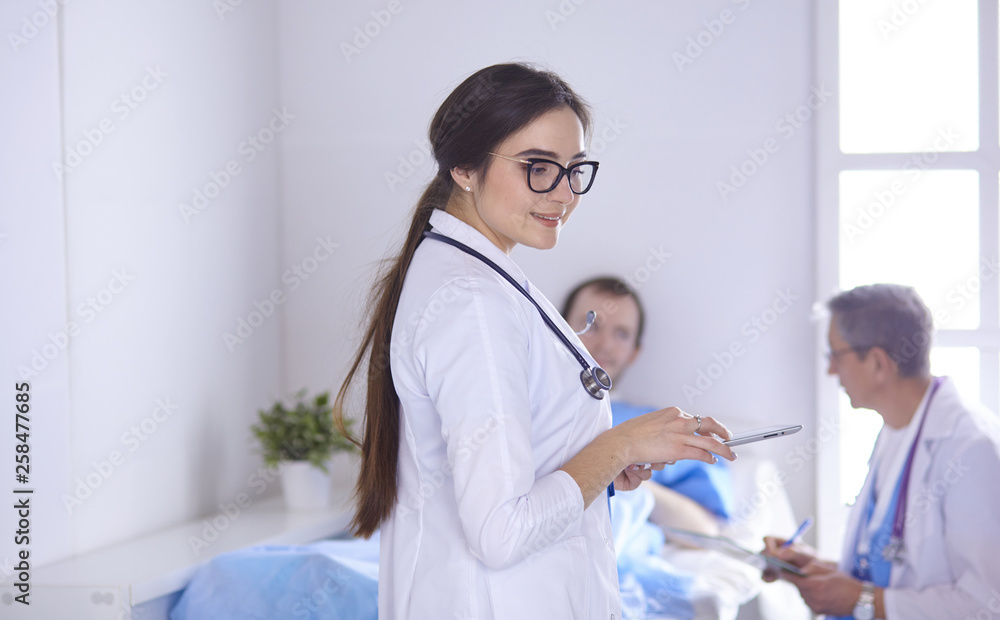 Fototapeta premium Doctor checking heart beat of patient in bed with stethoscope