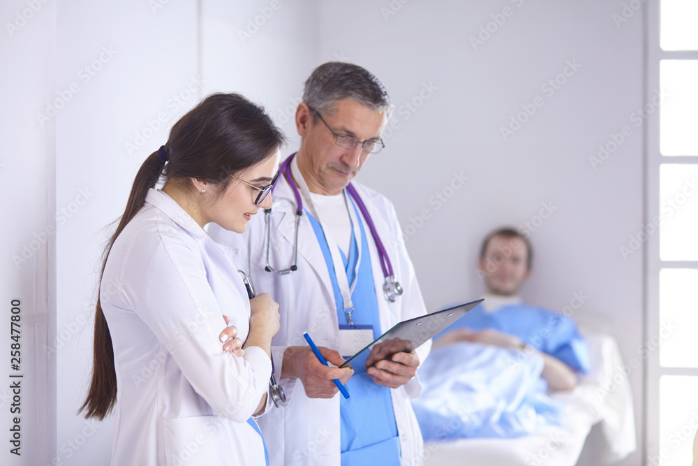 Doctor checking heart beat of patient in bed with stethoscope Doctor checking heart beat of patient in bed with stethoscope