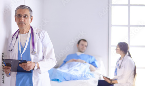 Doctor checking heart beat of patient in bed with stethoscope