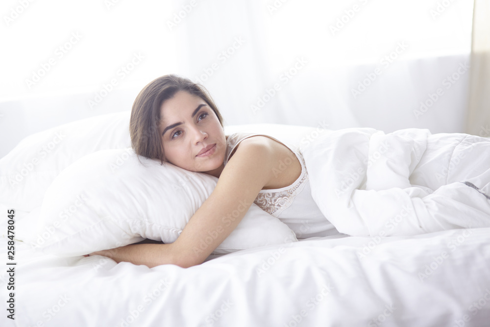 beautiful young woman basking in bed in the morning. Beautiful beautiful young woman basking in bed in the morning. Beautiful