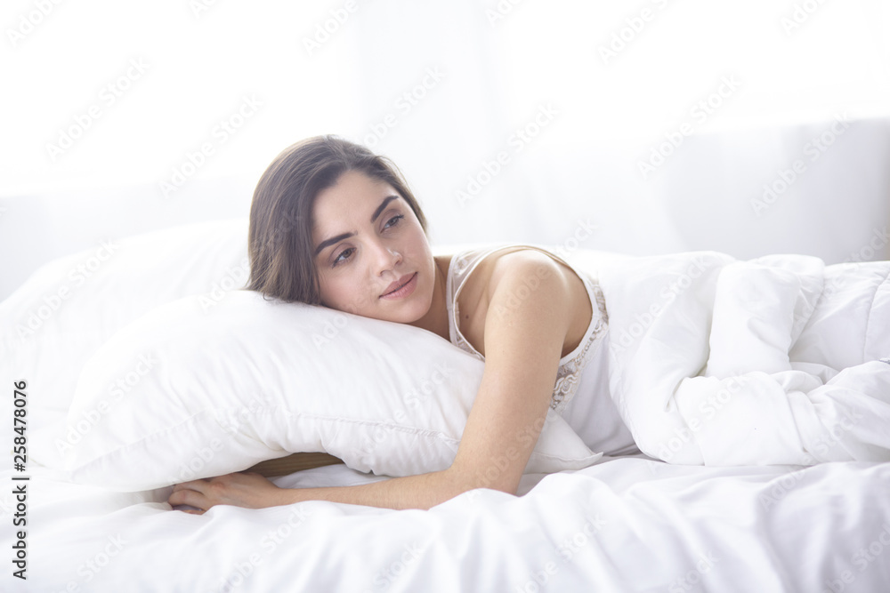 beautiful young woman basking in bed in the morning. Beautiful beautiful young woman basking in bed in the morning. Beautiful
