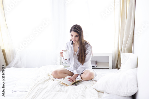 Young beautiful happy brunette woman in black silk dressing gow