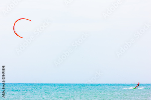 brave man kite sailing on the black sea with a sail wing in his hands led by the wind on a bright sunny day. village of the annunciation. сopy space.