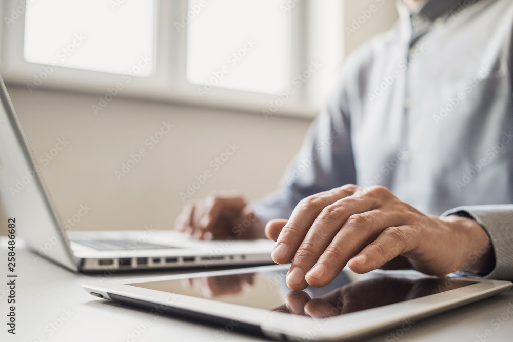 Men working on computer. Businessman using laptop and digital tablet at home. Internet marketing, freelance work, online education learning concept