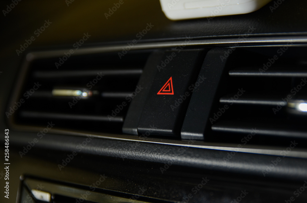 Emergency button close up macro shot on Malaysian car dashboard.