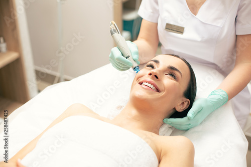 Close up of happy woman at the skin cleaning procedure
