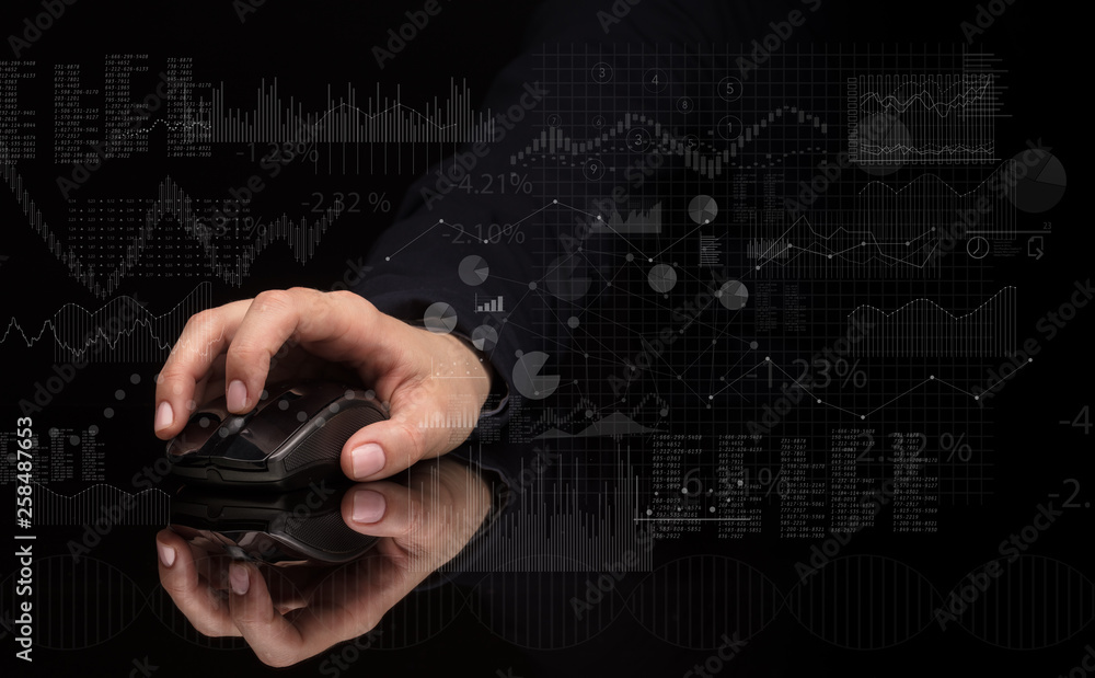 Fototapeta premium Hand using wireless mouse with financial concept on dark background 