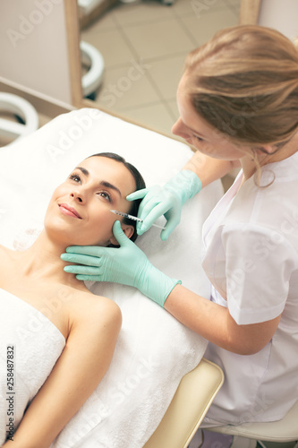 Top view of satisfied woman getting hyaluronic acid injection