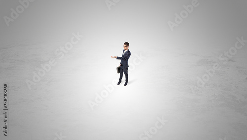 Young businessman standing alone in the middle of an empty space 