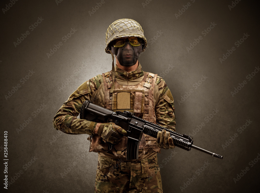 Soldier agent in a dark room with arms on his hand and gas mask
