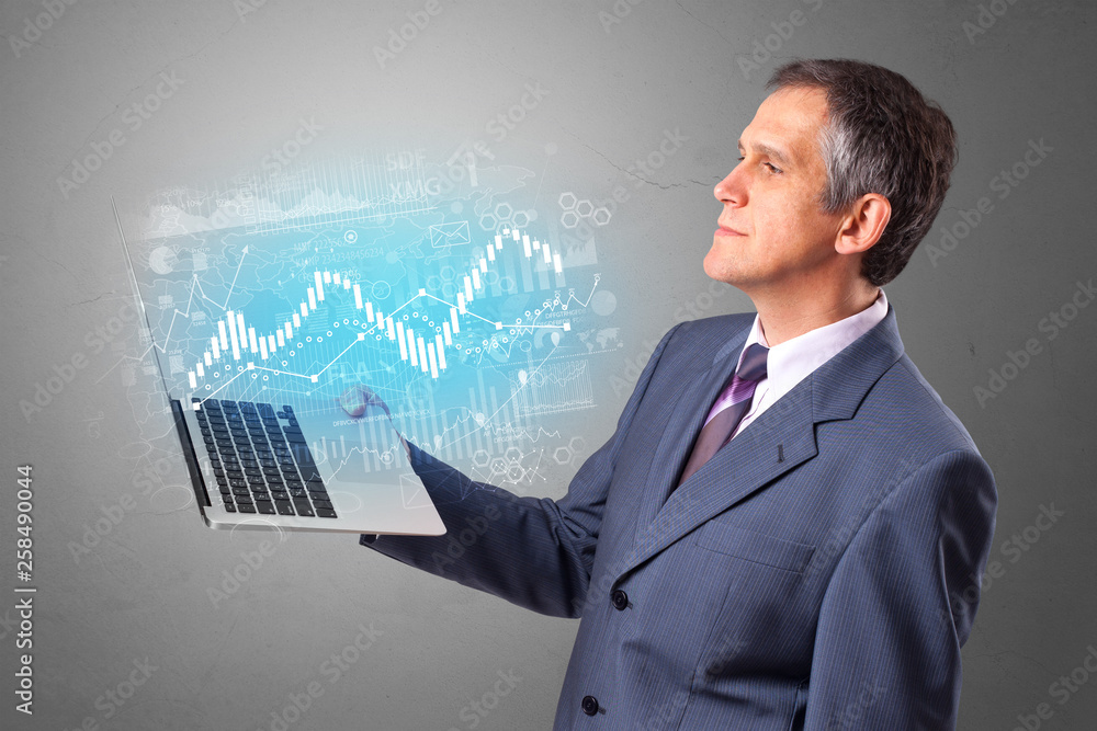 Man holding laptop projecting financial information, diagrams and charts
Man holding laptop projecting financial information, diagrams and charts