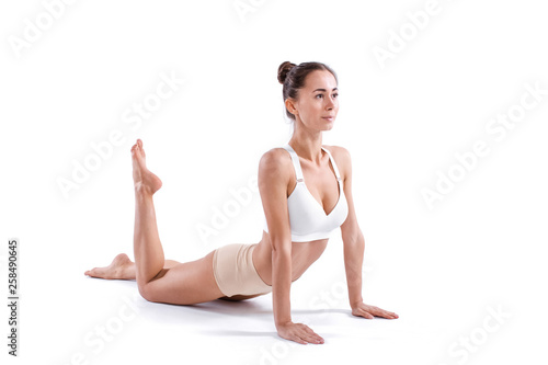 Beautiful young woman doing yoga or pilates exercise isolated on white background.