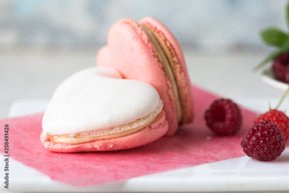 A beautiful heart made of macaroons and raspberry. Valentines day consept. flat lay, top view. A beautiful heart made of macaroons and raspberry. Valentines day consept. flat lay, top view.