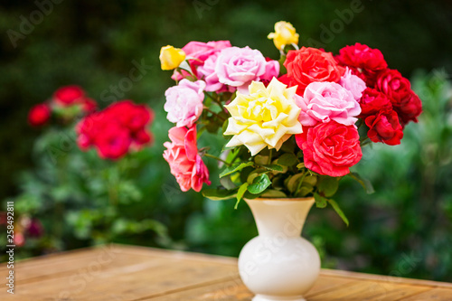 Garden roses in vintage white vase outdoors. © ifiStudio