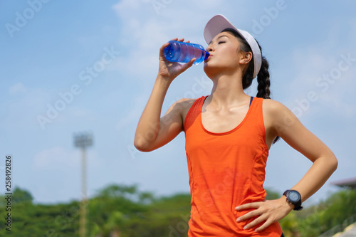 Woman runners are drinking water. After training