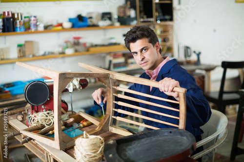 Craftsman repairing chair in workshop