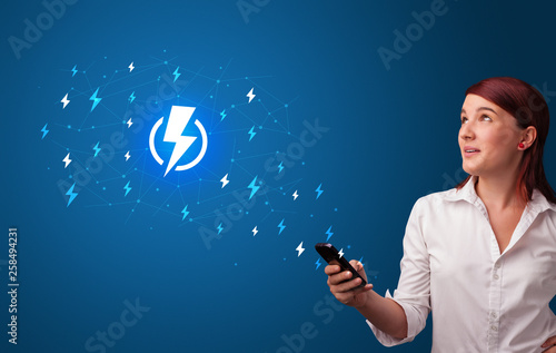 Young person using phone with power concept
 photo