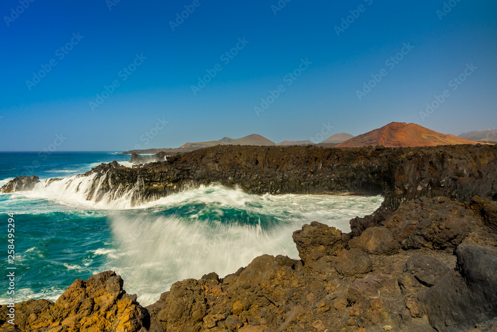 Spain, Lanzarote, Splashing giant waves breaking in volcanic bay of los hervideros