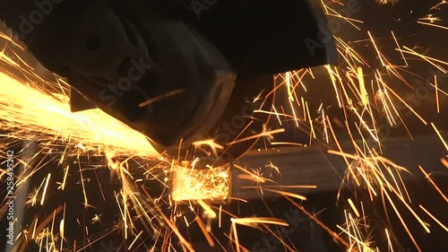Angle grinder cutting a rectangular metallic tube with speedy yellow scintillas