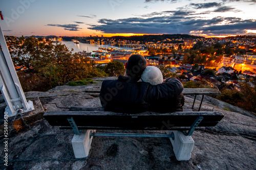 Love couple sitting night view city Sandefjord