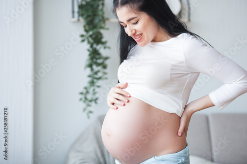 Young pregnant woman having a backache. Expecting woman feeling bad. Pregnant woman suffering from pain. Free Download Young pregnant woman having a backache. Expecting woman feeling bad. Pregnant woman suffering from pain. - GFXLoad
