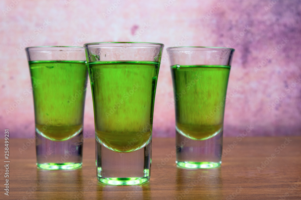 Three glasses of absinthe in a shot glass Three glasses of absinthe in a shot glass