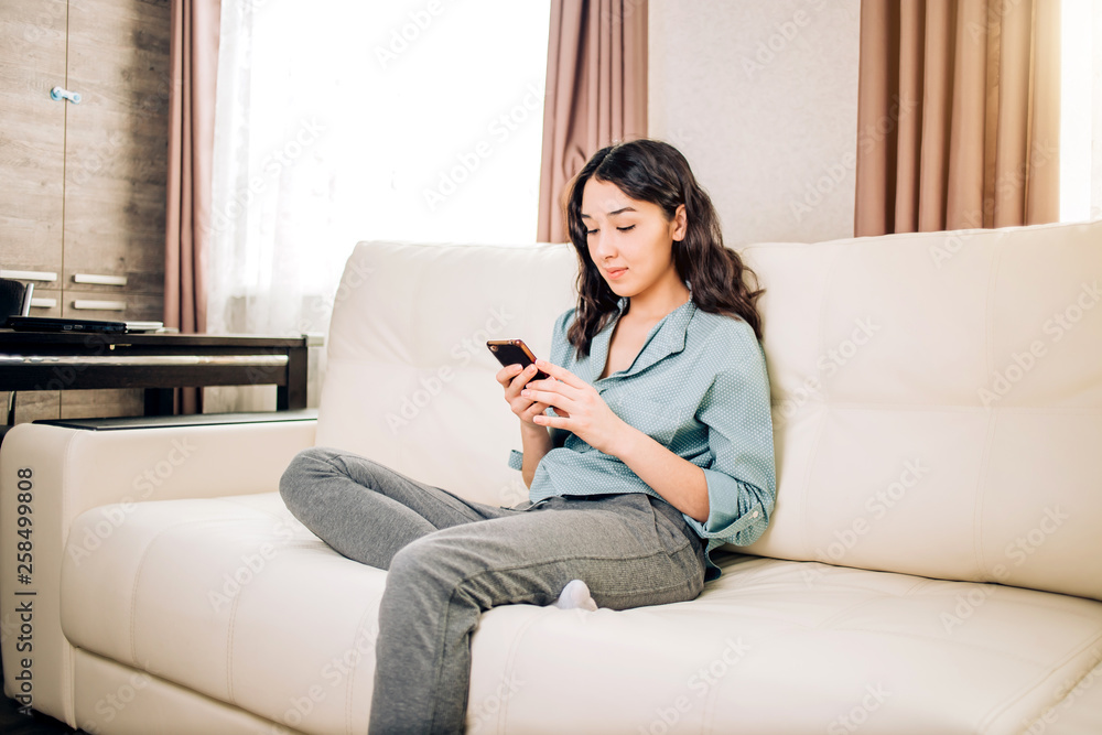 Obraz premium Young woman using smartphone at home