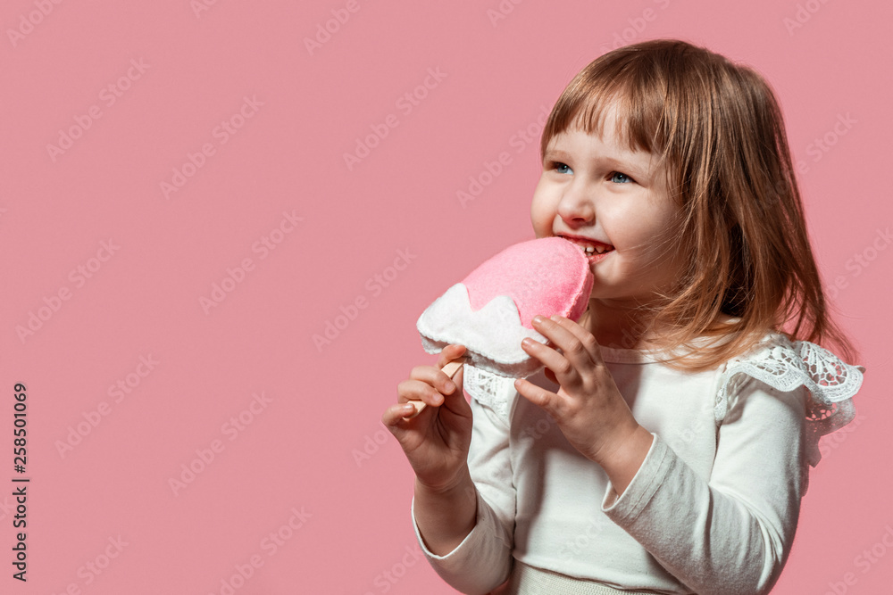 happy kid with ice cream ice cream in hand on a pink coral background. with free text space. happy kid with ice cream ice cream in hand on a pink coral background. with free text space.