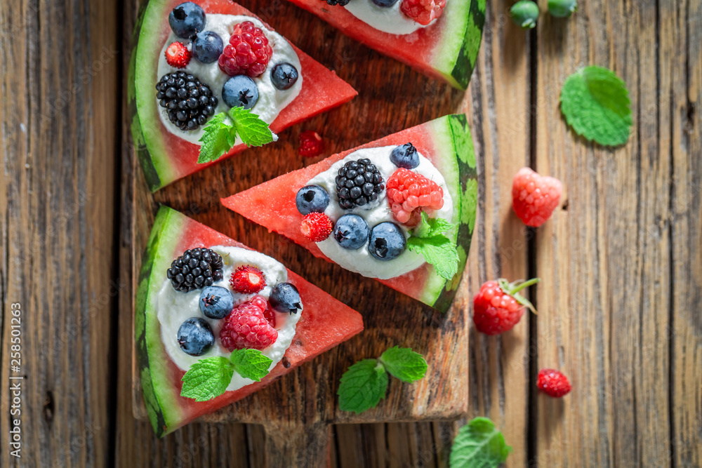 Delicious watermelon pizza with whipped cream and fresh berry fruits