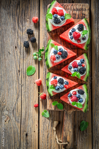 Healthy watermelon pizza with whipped cream and fresh berry fruits