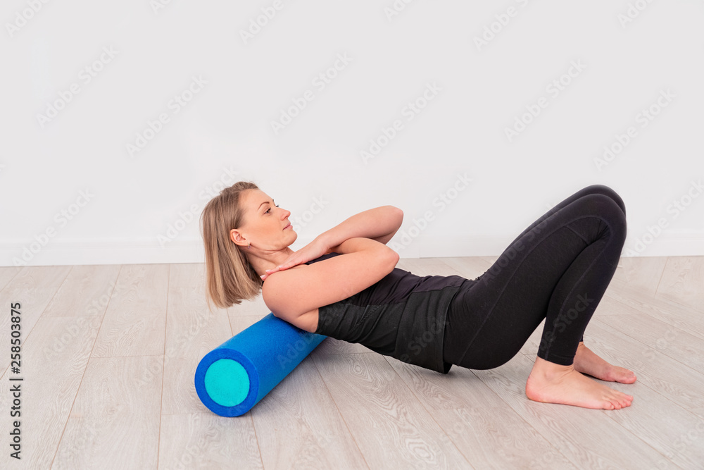 Obraz premium woman doing exercise with a roller