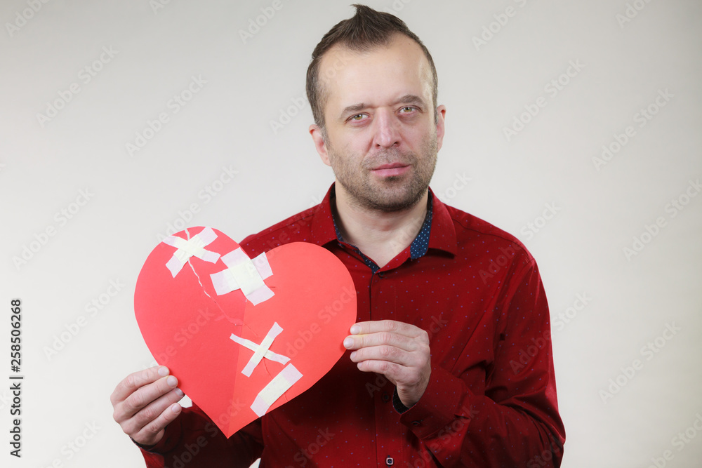 Sad adult man holding broken heart Sad adult man holding broken heart
