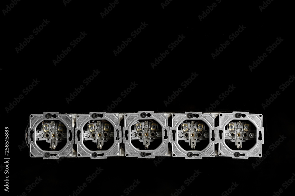 Five outlets in line, disassembled and mounted in black glass wall Five outlets in line, disassembled and mounted in black glass wall