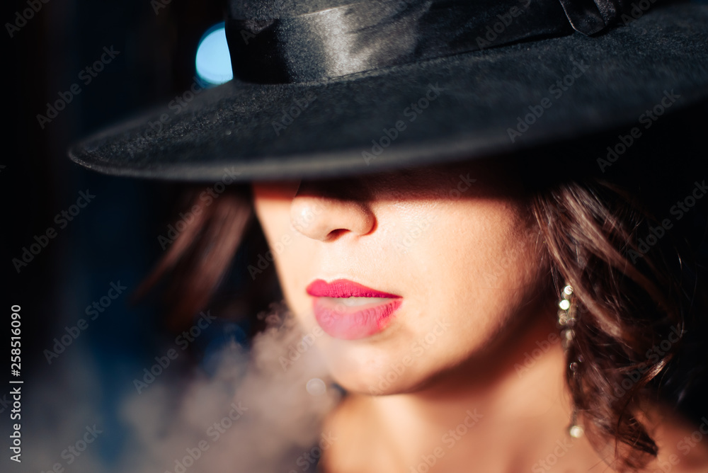 a beautiful brunette girl in a black dress smokes a hookah and lets out smoke a beautiful brunette girl in a black dress smokes a hookah and lets out smoke