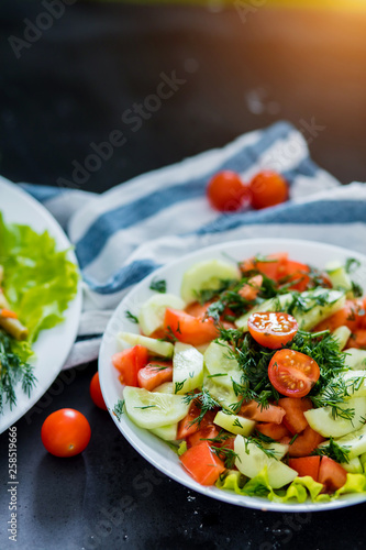 Fresh spring vegetable salad on a black background, close-up